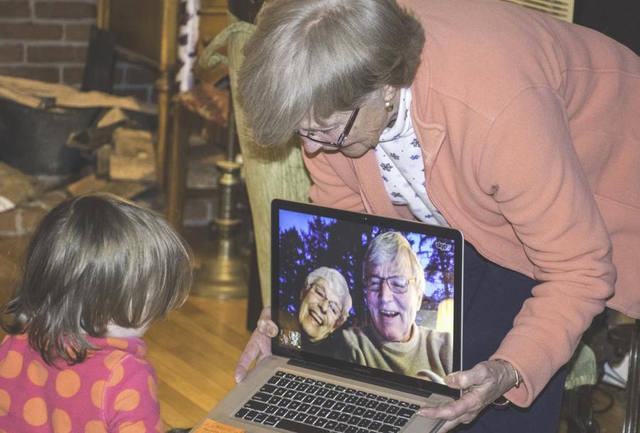 Ældre dame viser computer til barn
